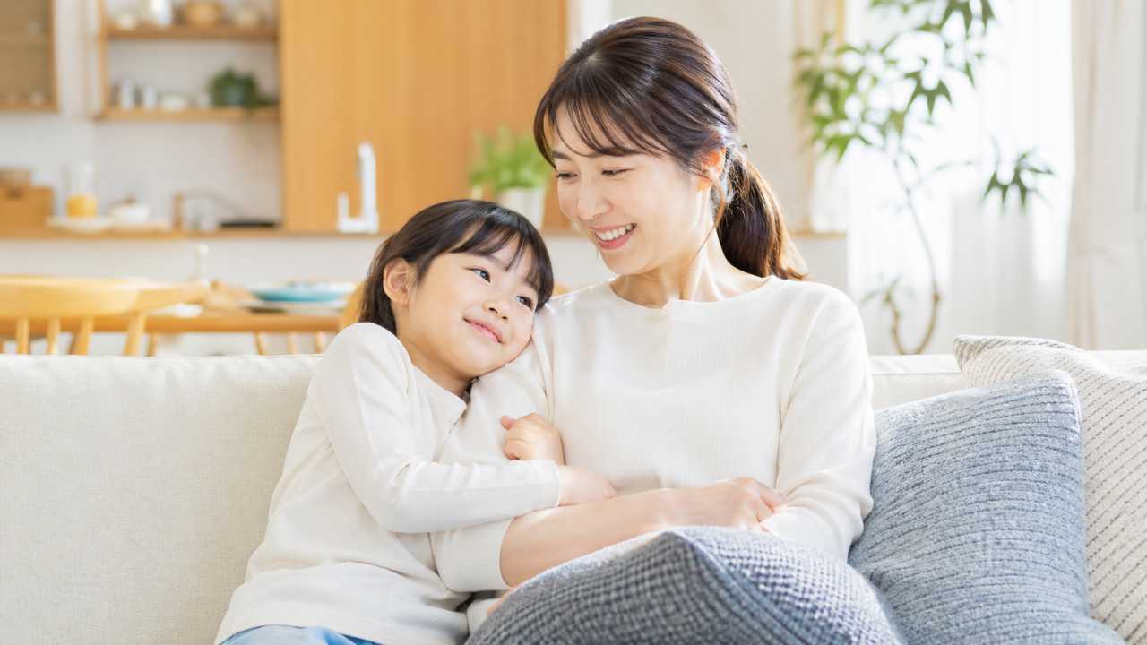 親子がリビングで寄り添って座っている様子