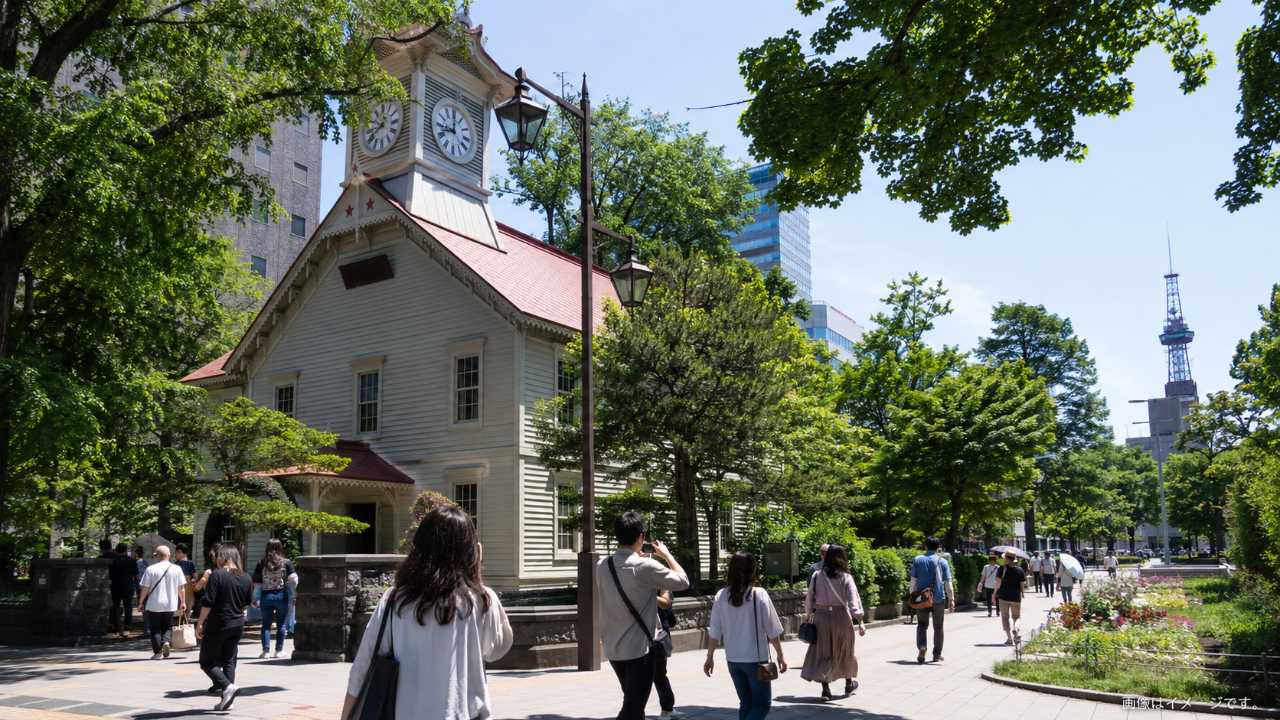 札幌市時計台と大通公園周辺を歩く観光客のイメージ