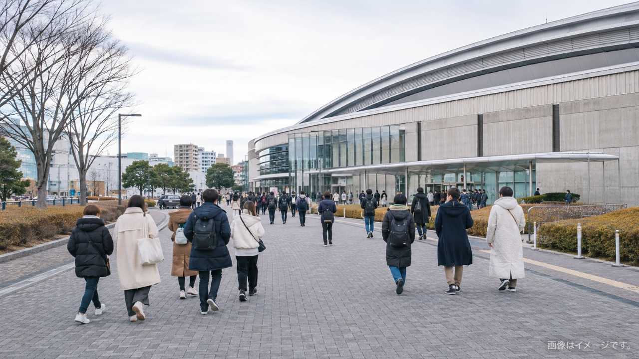 イベント当日の体育館周辺で来場者が整然と歩く様子