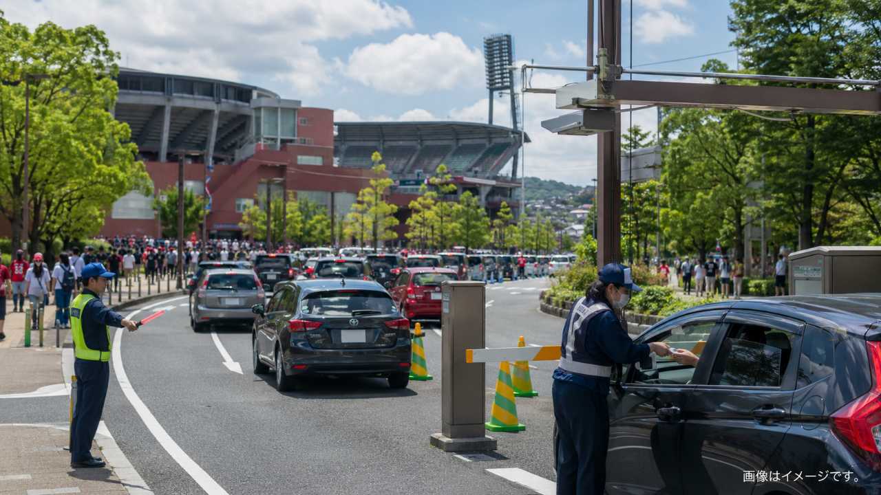 試合日のボールパーク周辺道路、誘導員の案内、駐車券を確認して入庫する車、混雑しつつも秩序ある雰囲気