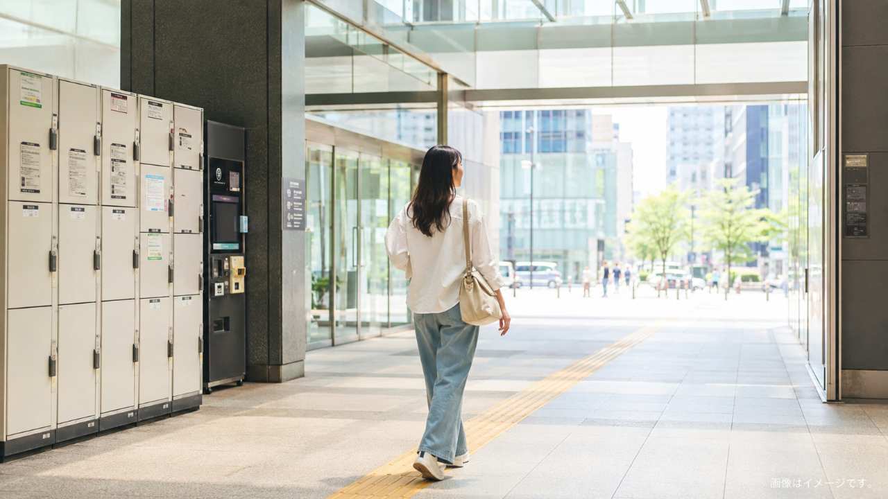 札幌駅周辺の明るい駅コンコースを背景に、旅行者がスーツケースを預けて身軽に観光へ向かう様子
