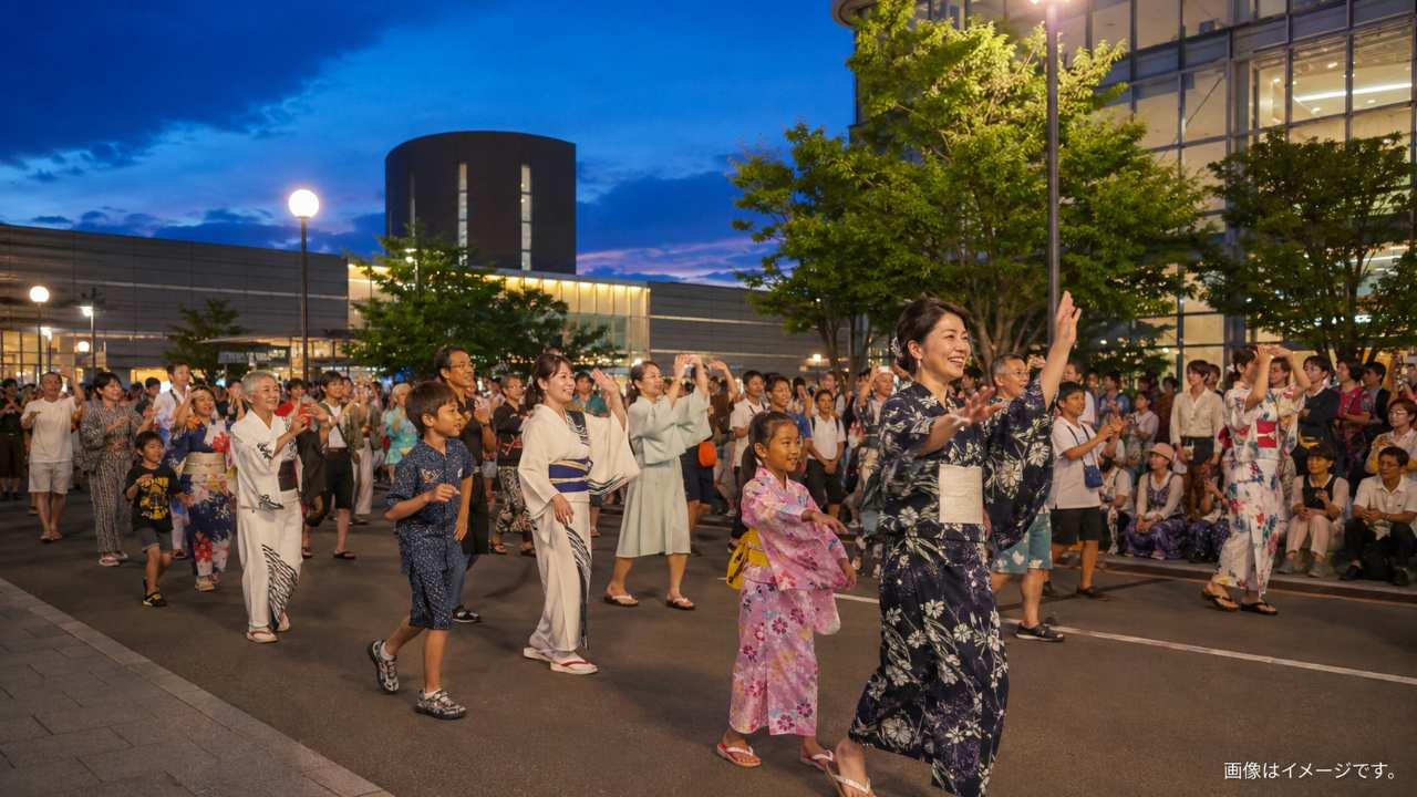 函館駅前の広い通りで、幅広い世代の市民が笑顔で函館いか踊りを踊る夏祭りのパレード